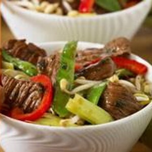 Im Wok karamelisiertes Schweinefleisch mit Peperoni, Honig und Koriander Im Wok karamelisiertes Schweinefleisch mit Peperoni, Honig und Koriander